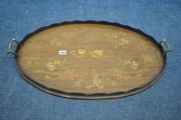 AN EDWARDIAN MAHOGANY AND MARQUETRY INLAID OVAL TRAY, with a wavy gallery and twin brass handles,