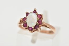 A 9CT GOLD OPAL AND RUBY RING, centring on an oval cut opal, prong set within a surround of eight