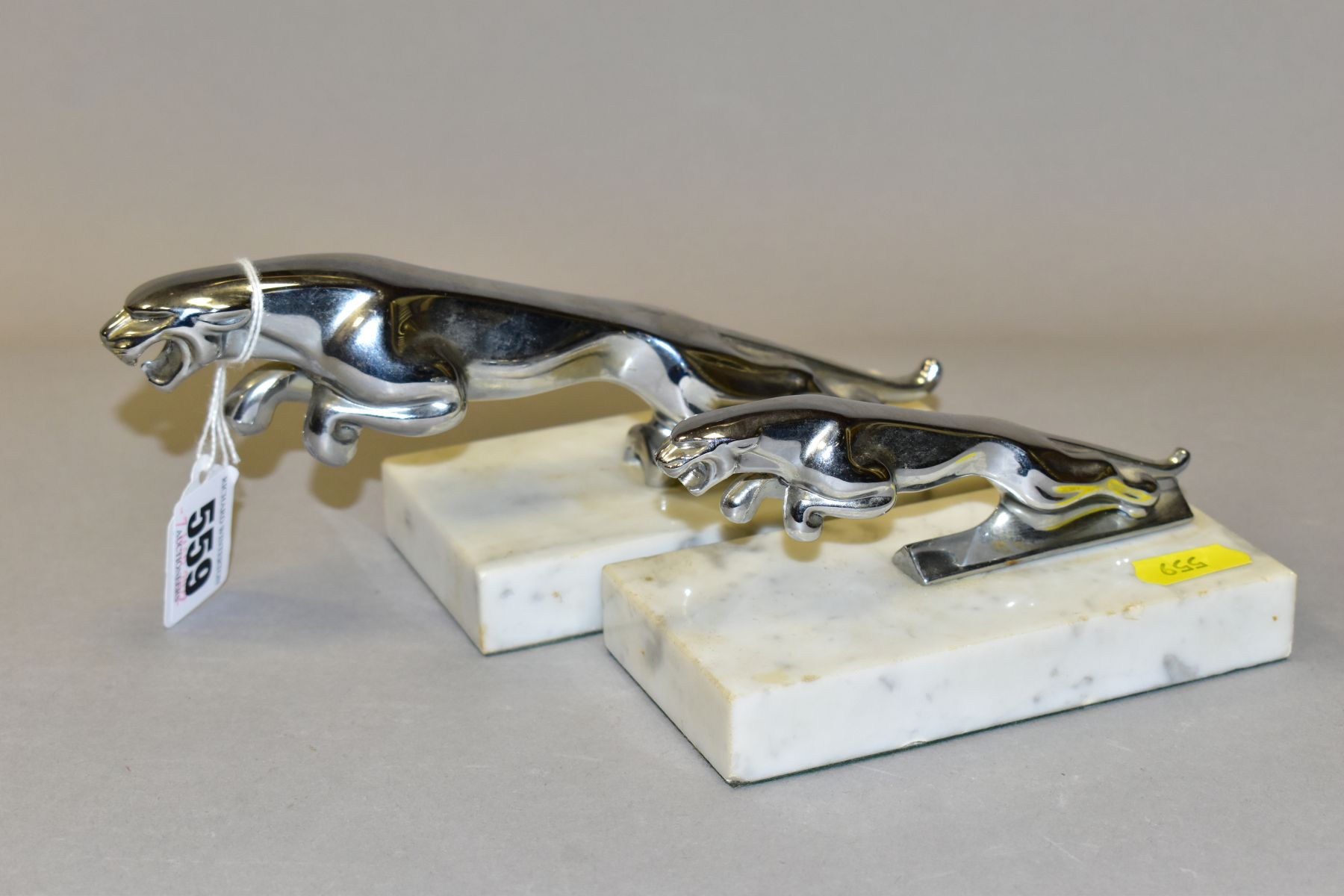 TWO CHROMED JAGUAR MASCOTS ON MARBLE PLINTHS, leaping jaguars in two different sizes, lengths 12.5cm