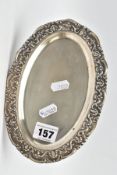 AN OVAL WHITE METAL TRAY, embossed foliate rim, engraved to the reverse of the base 'Presented to