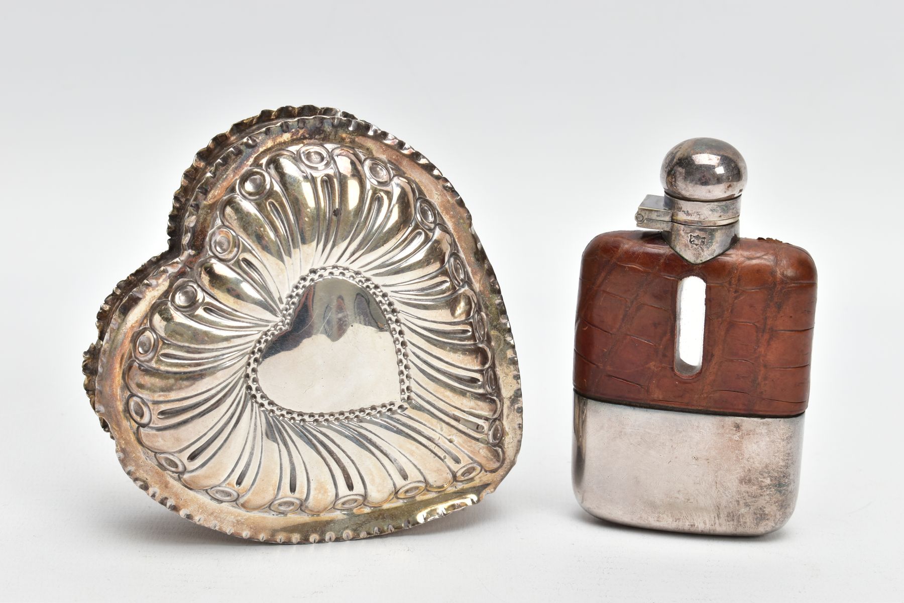 A SILVER TRINKET AND A HIPFLASK, a late Victorian embossed heart shaped trinket, with a vacant heart