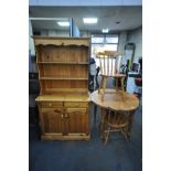 A PINE CIRCULAR KITCHEN TABLE, diameter 91cm x height 75cm, two chairs, and a pine dresser with