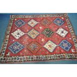 A PERSIAN HAMEDAN RUG, with twelve medallions containing various designs, within a red field and