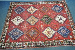 A PERSIAN HAMEDAN RUG, with twelve medallions containing various designs, within a red field and