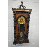 A LATE VICTORIAN WALNUT AND EBONISED VIENNA WALL CLOCK, horse pediment, above a shaped glazed door