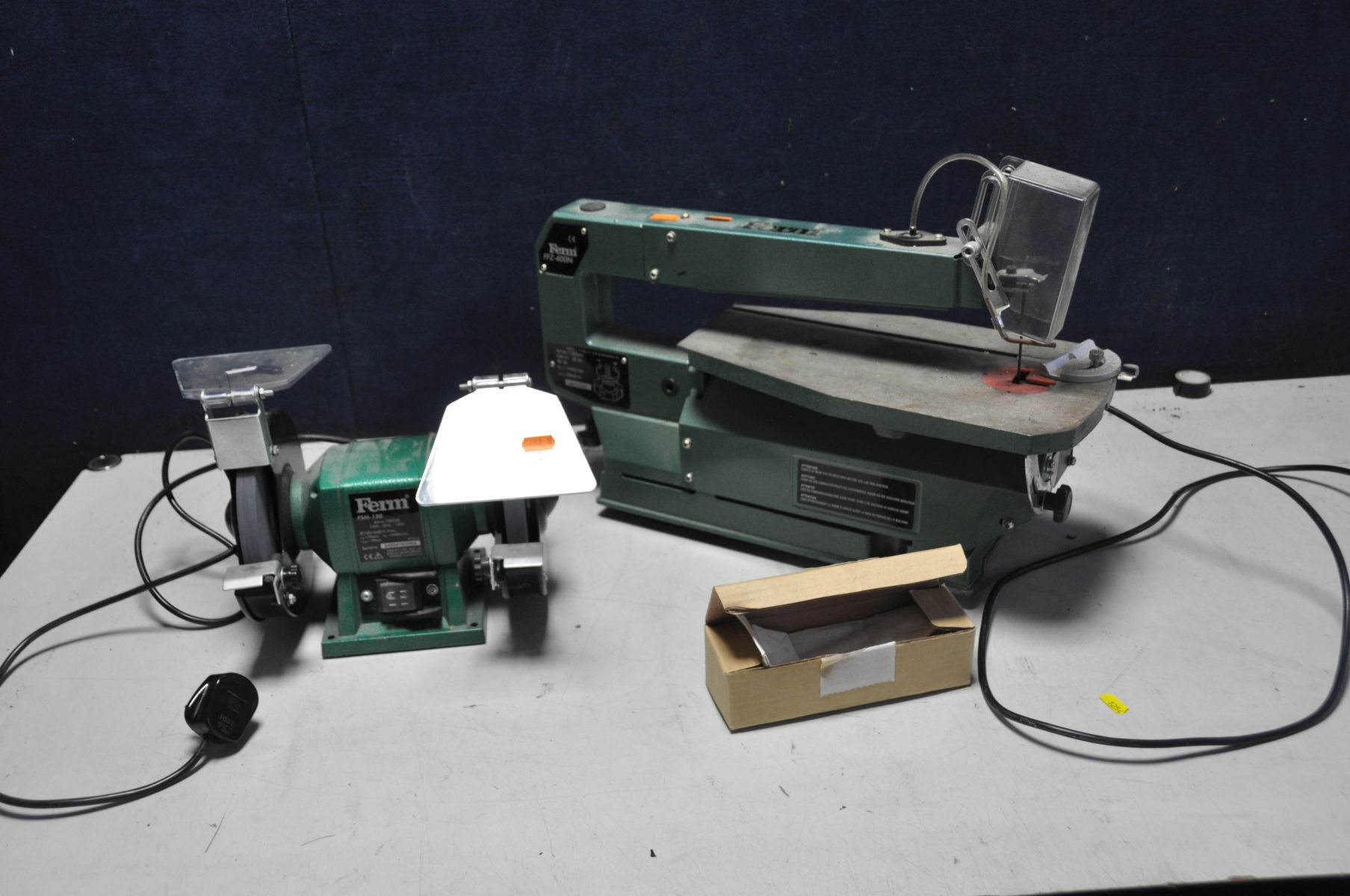 A FERM FFZ400N SCROLL SAW with a box of spare blade and mitre guide along with a Ferm FSM150 bench