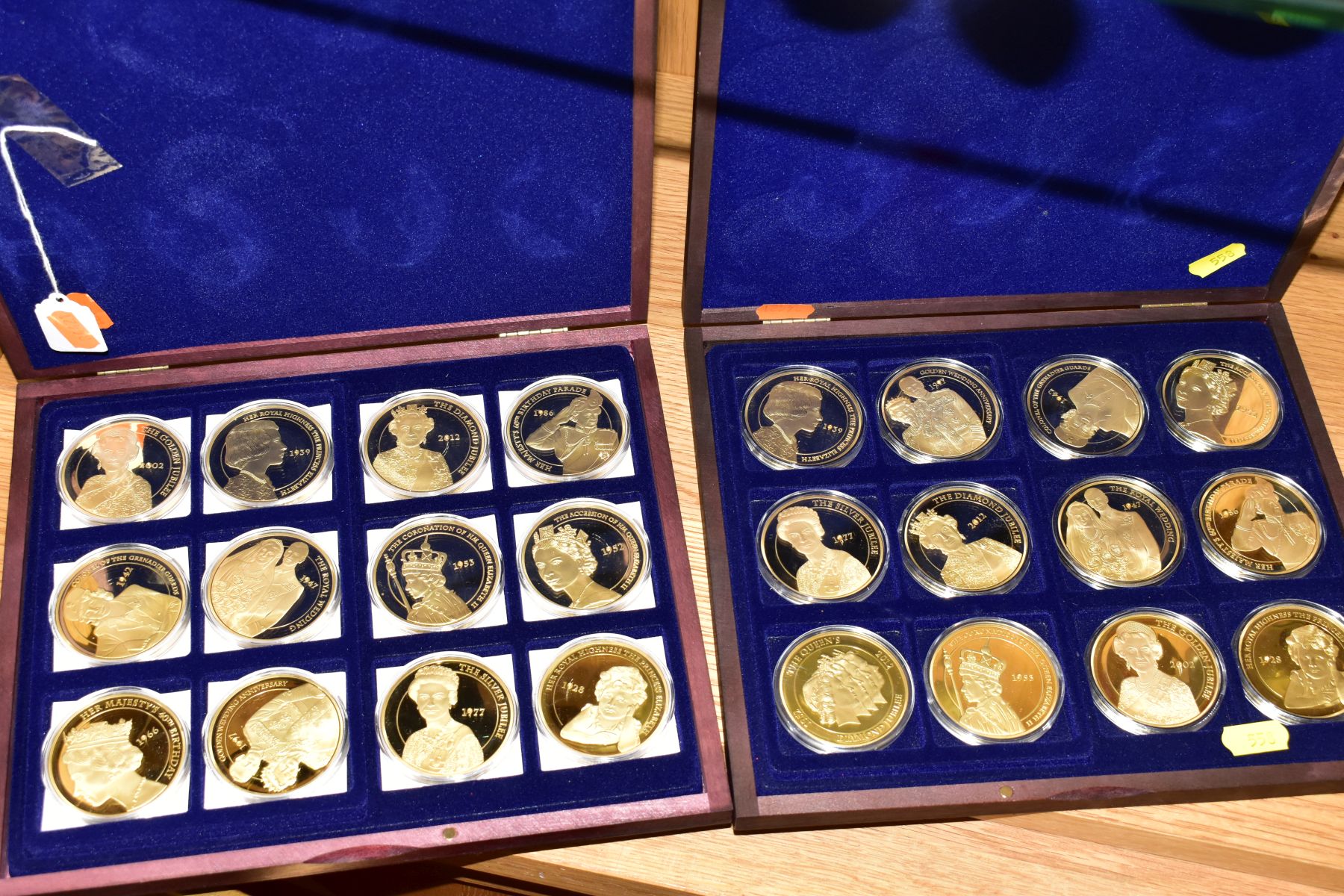 TWO COMMEMORATIVE GOLD PLATED PROOF COIN SETS, each coin featuring portraits of Queen Elizabeth II
