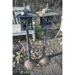 A PAIR OF CAST IRON ORIENTAL GARDEN LANTERNS with a pagoda style candle holder, cylindrical stem and
