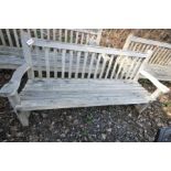 A LARGE HARDWOOD GARDEN BENCH with slatted seat and back and scrolled arm rests width 188cm (