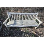 A LARGE HARDWOOD GARDEN BENCH with slatted seat and back and scrolled arm rests width 188cm (some