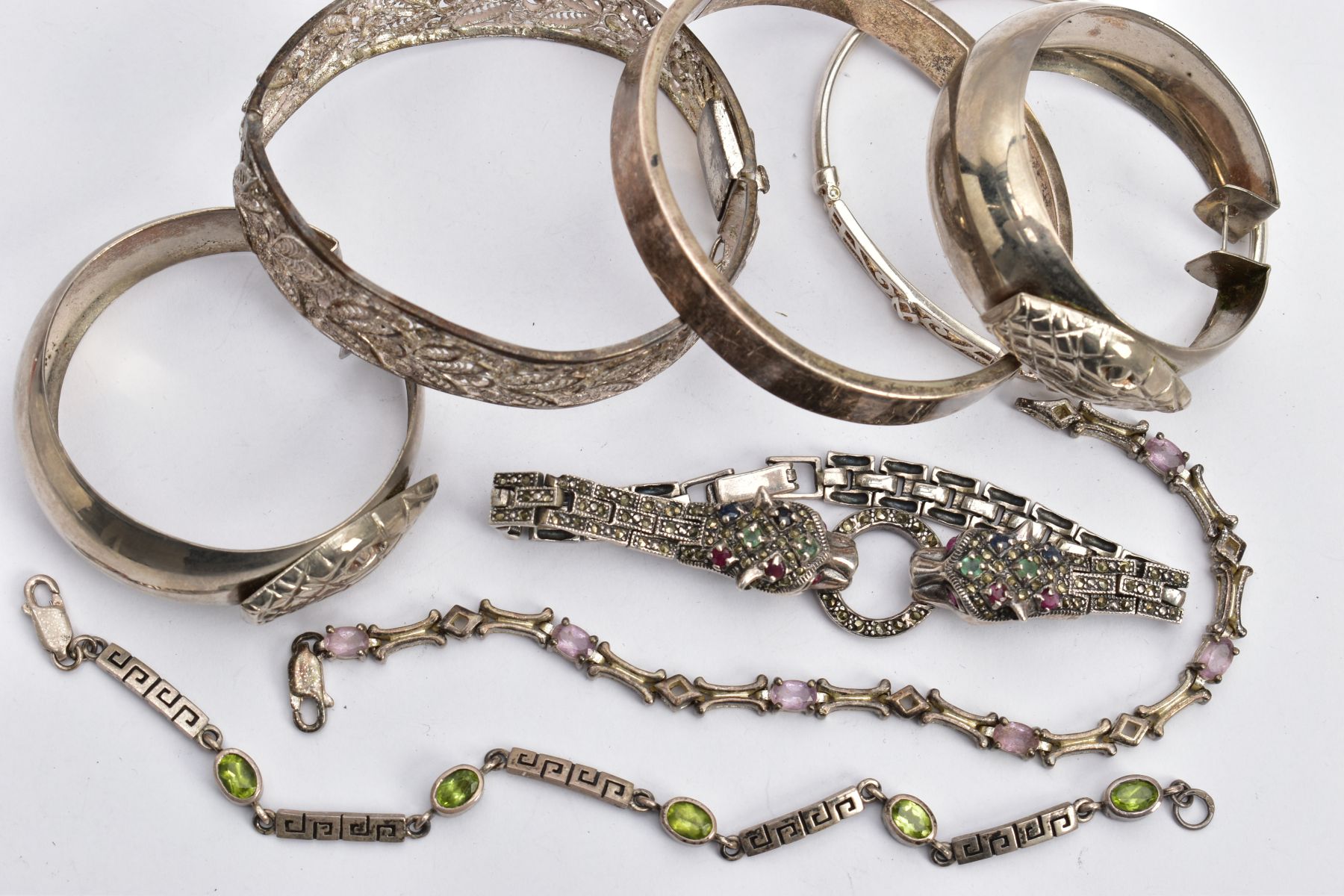 SIX BRACELETS AND A PAIR OF HOOP EARRINGS, to include a silver double jaguar head bracelet set