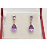 A PAIR OF YELLOW METAL AMETHYST DROP EARRINGS, each designed with a claw set, pear cut amethyst