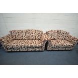 A CREAM AND RED FLORAL UPHOLSTERED TWO PIECE SUITE comprising two two seat setees, largest width