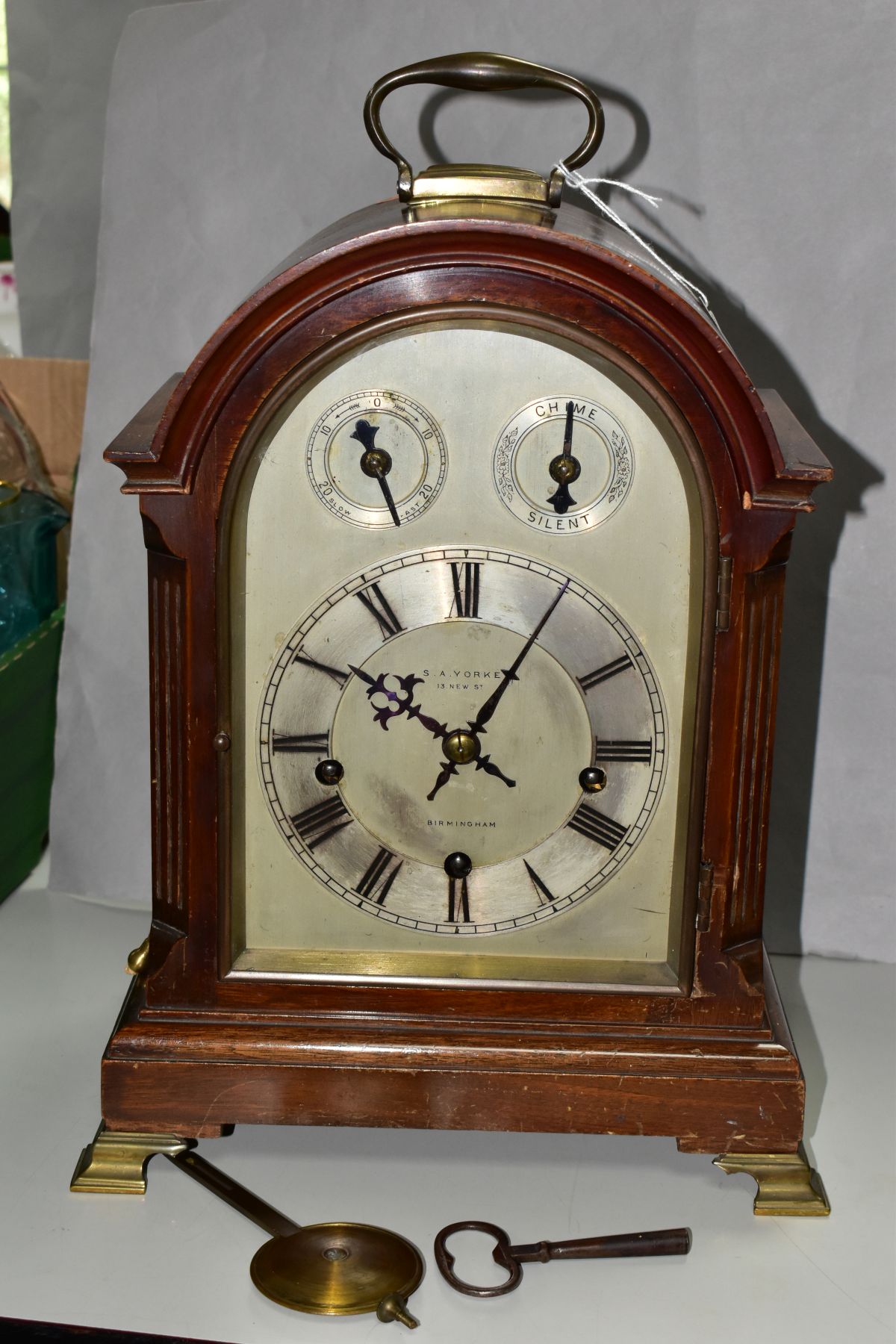 AN EARLY 20TH CENTURY MAHOGANY CASED DOME TOP CHIMING BRACKET CLOCK, hinged brass carrying handle to