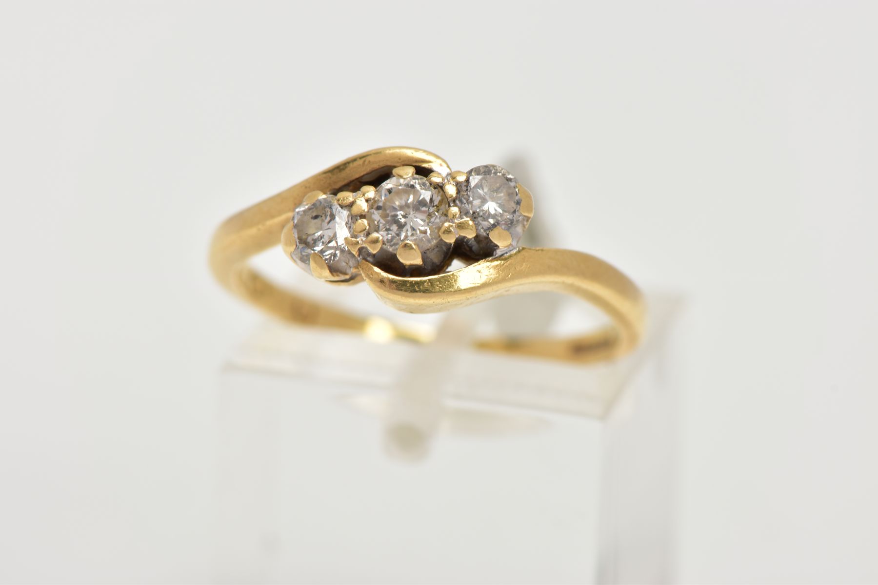 AN 18CT GOLD THREE STONE DIAMOND RING, cross over design set with three round brilliant cut