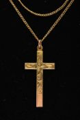 A YELLOW METAL CROSS PENDANT, a large cross detailing a scrolling foliage pattern, approximate