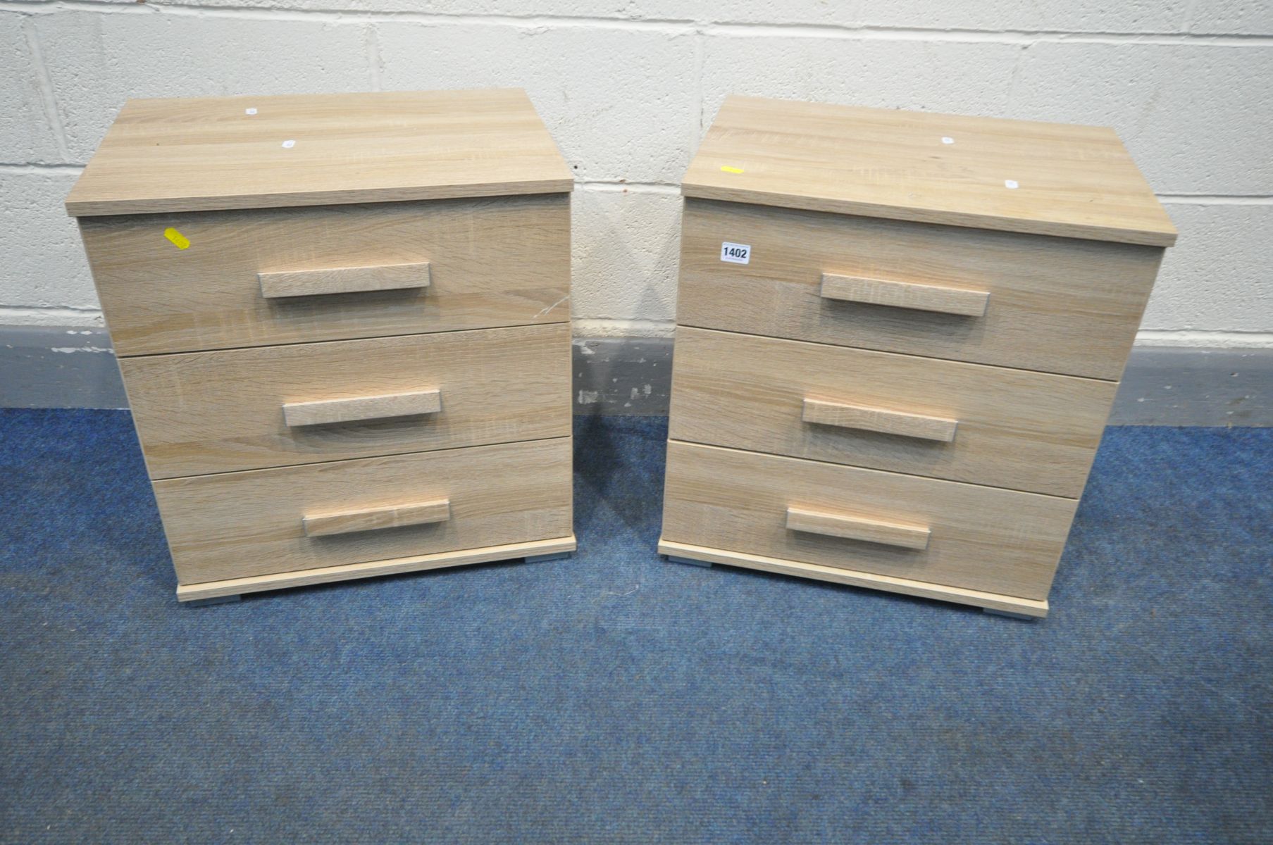 A PAIR OF OAK EFFECT THREE DRAWER BEDSIDE CABINETS, width 50cm x depth 37cm x height 54cm (