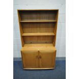 AN ERCOL WINDSOR BLONDE ELM BOOKCASE ON CABINET, with two adjustable shelves, over double cupboard