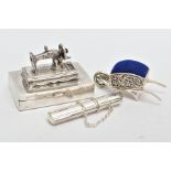 THREE WHITE METAL ITEMS, to include a silver sewing needle box fitted with a sewing machine to the