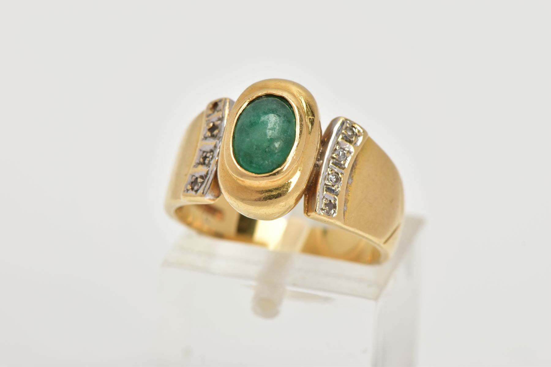 AN 18CT GOLD EMERALD AND DIAMOND RING, an oval cabochon emerald stone, approximate dimensions length