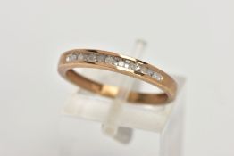 A 9CT GOLD DIAMOND HALF ETERNITY RING, designed with a row of channel set single cut diamonds,