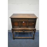 AN OAK PANELLED BLANKET CHEST, on a stand with two drawers, turned legs united by stretchers,