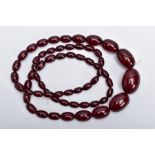 A CHERRY AMBER BAKELITE NECKLACE, graduating oval beads, largest measuring approximately 11mm x 7mm,