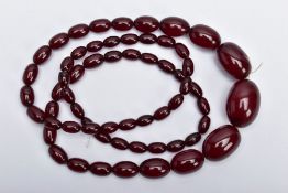 A CHERRY AMBER BAKELITE NECKLACE, graduating oval beads, largest measuring approximately 11mm x 7mm,