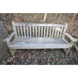 A LARGE HARDWOOD GARDEN BENCH with slatted seat and back and scrolled arm rests width 188cm (some