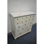 A CREAM PAINTED BANK OF NINETEEN DRAWERS of various sizes, width 90cm x depth 37cm x height 100cm (