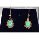 A PAIR OF OPAL CABOCHON DROP EARRINGS, yellow metal drop earrings each of an oval form, oval white