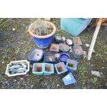 A BOX CONTAINING EIGHTEEN SMALL GLAZED PLANT POTS in green, blue and natural colours of various