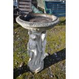 A COMPOSITE BIRDBATH in the form of three scantily clad maidens around a column holding a bowl