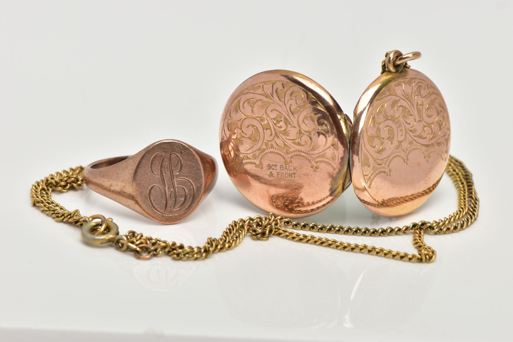A 9CT GOLD SIGNET RING AND YELLOW METAL LOCKET, an oval shaped signet ring, engraved with the letter