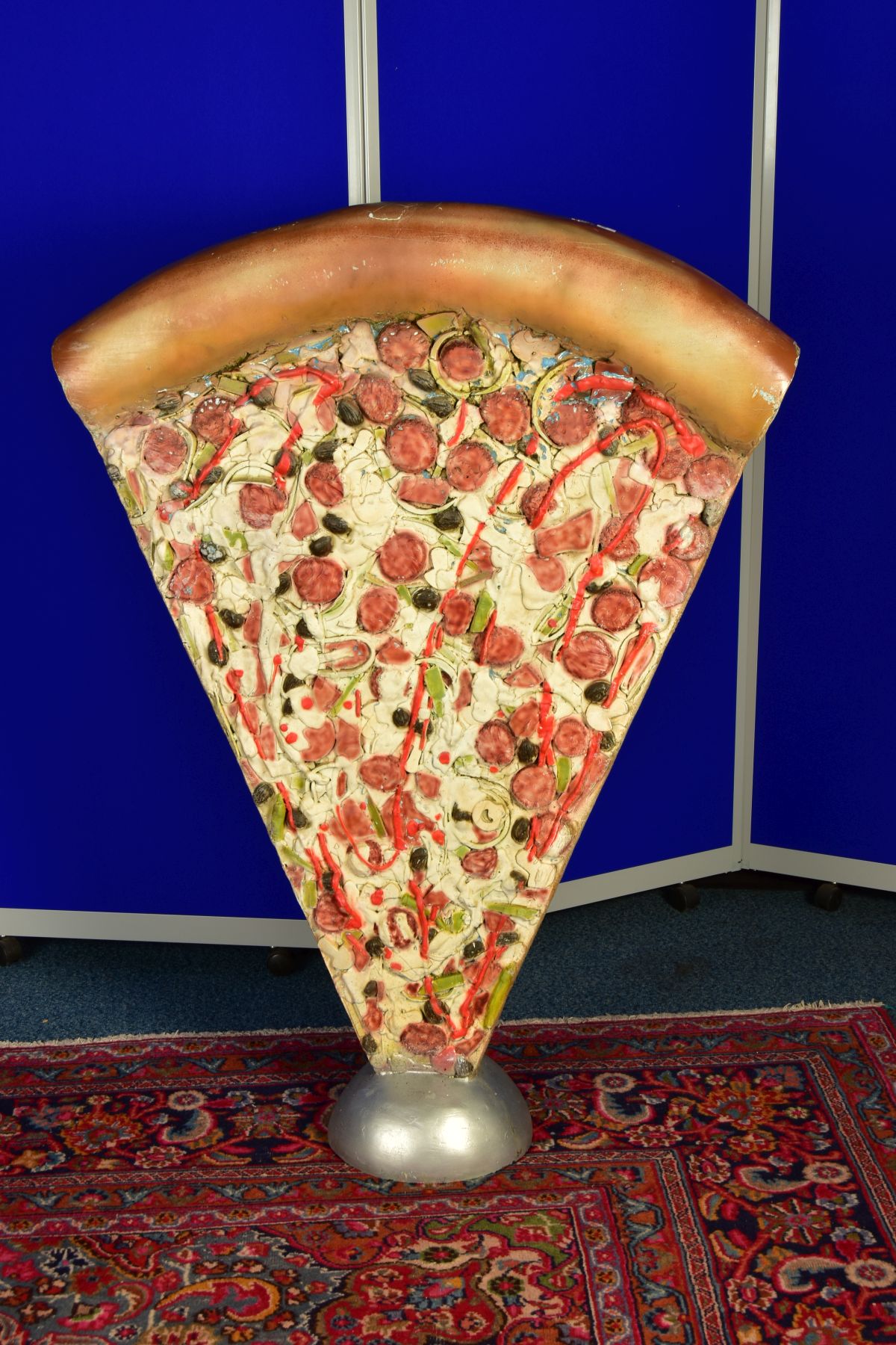 AN UPRIGHT JUMBO PIZZA ADVERTISING SIGN, detailed with a mass of toppings and deep crust, cast