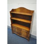 A REPRODUX MAHOGANY WATERFALL OPEN BOOKCASE, with double cupboard doors, width 84cm x depth 26cm x