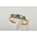 AN EMERALD AND DIAMOND FIVE STONE RING, an emerald cut emerald set centrally with two round