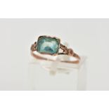 A YELLOW METAL GEM SET RING, designed with a rectangular cut light blue stone, rough bezel