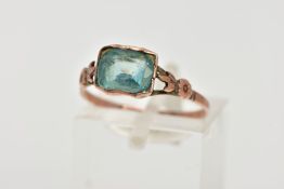 A YELLOW METAL GEM SET RING, designed with a rectangular cut light blue stone, rough bezel