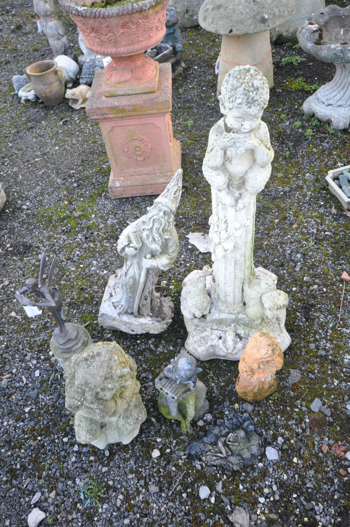 SEVEN MYTHICAL GARDEN FIGURES, including a composite man sitting on a ruined column with animals
