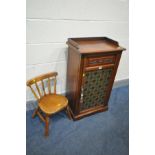 AN EDWARDIAN MAHOGANY MUSIC CABINET, raised back, single cupboard door with carved decoration and