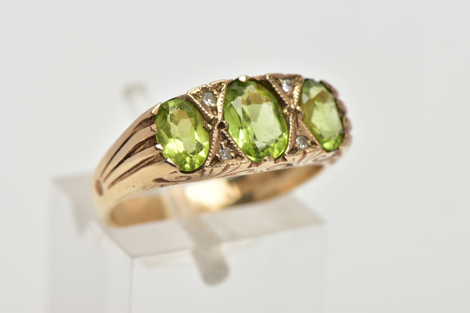 A MODERN 9CT GOLD SEVEN STONE DRESS RING, designed with three oval cut peridots, interspaced with - Image 4 of 4