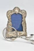 A SILVER PHOTO FRAME, TEASPOON AND A MAGNIFYING GLASS, the photo frame of a wavy rectangular form,