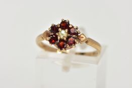 A 9CT GOLD GARNET AND PEARL CLUSTER RING, centring on a seed pearl, within a surround of six