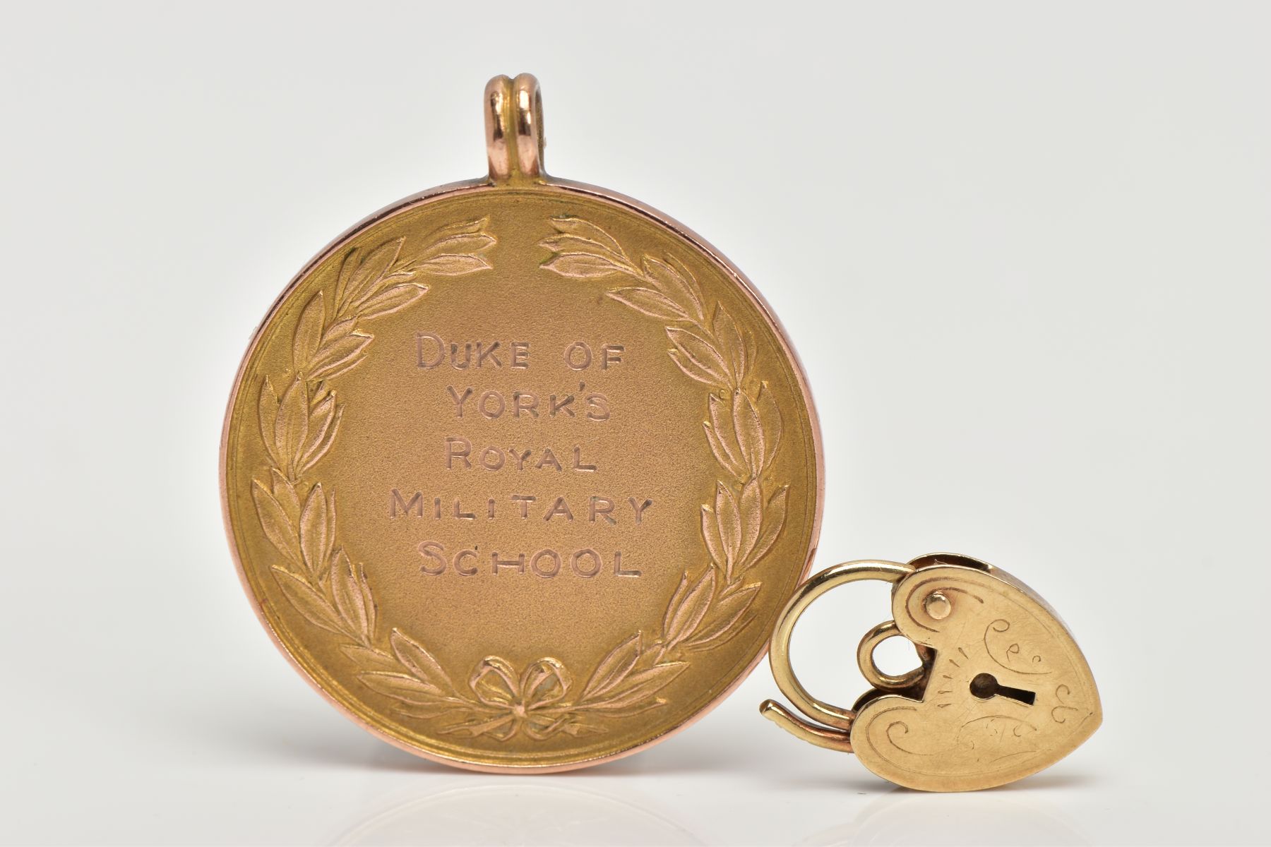 A 9CT GOLD MEDALLION AND YELLOW METAL CHARM, a yellow gold round medallion signed 'Duke of York's