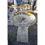 A MODERN COMPOSITE GARDEN URN, with fluted balustered detail sat on square base with ribbon and swag
