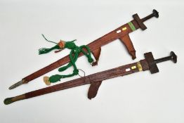 A PAIR OF TOUREG SWORDS, complete with leather scabbard, one has etchings to blade, the other design