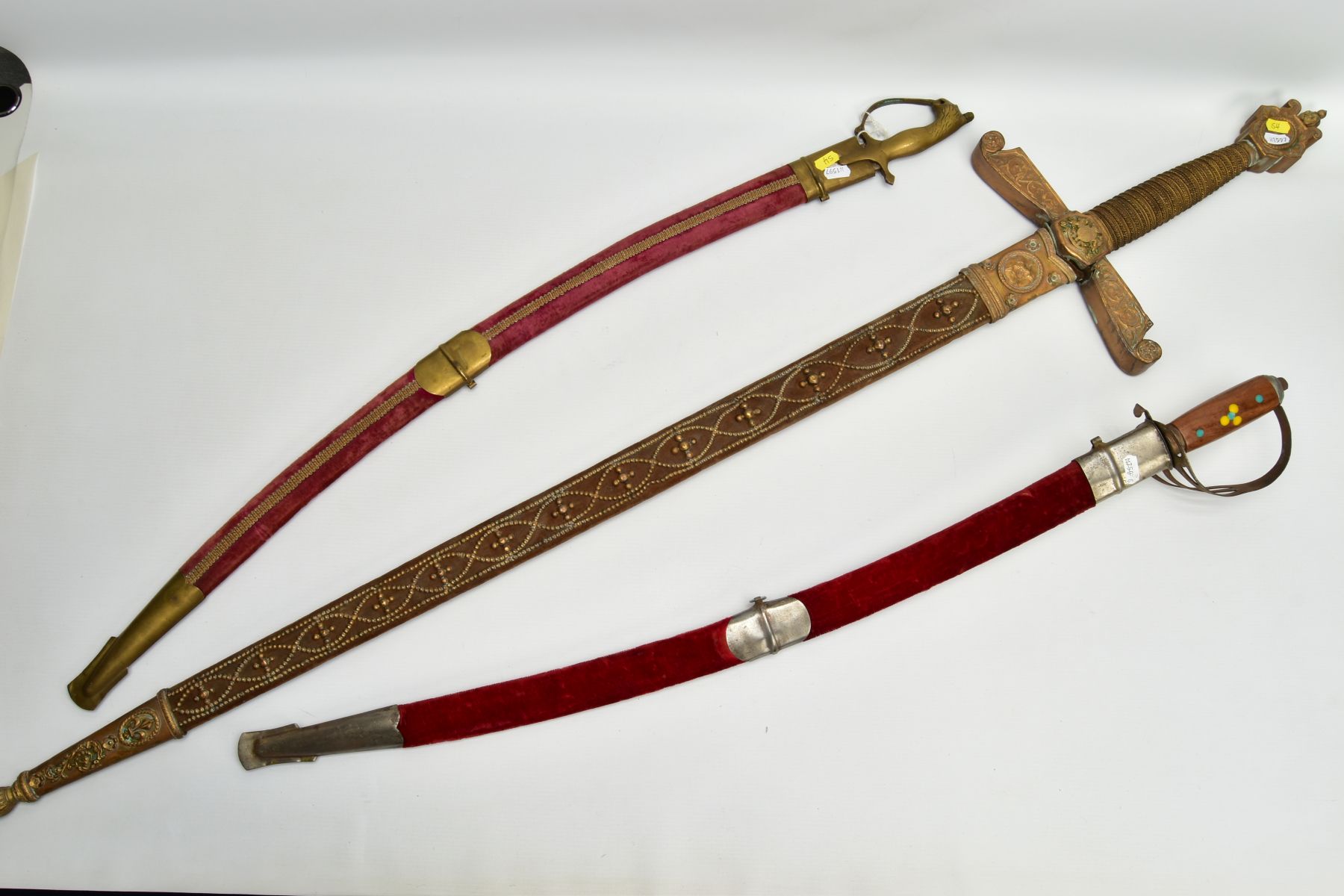 TWO ASIAN/INDIAN TOURIST STYLE CURVED SWORDS in wooden and suede scabbards, one id marked made in