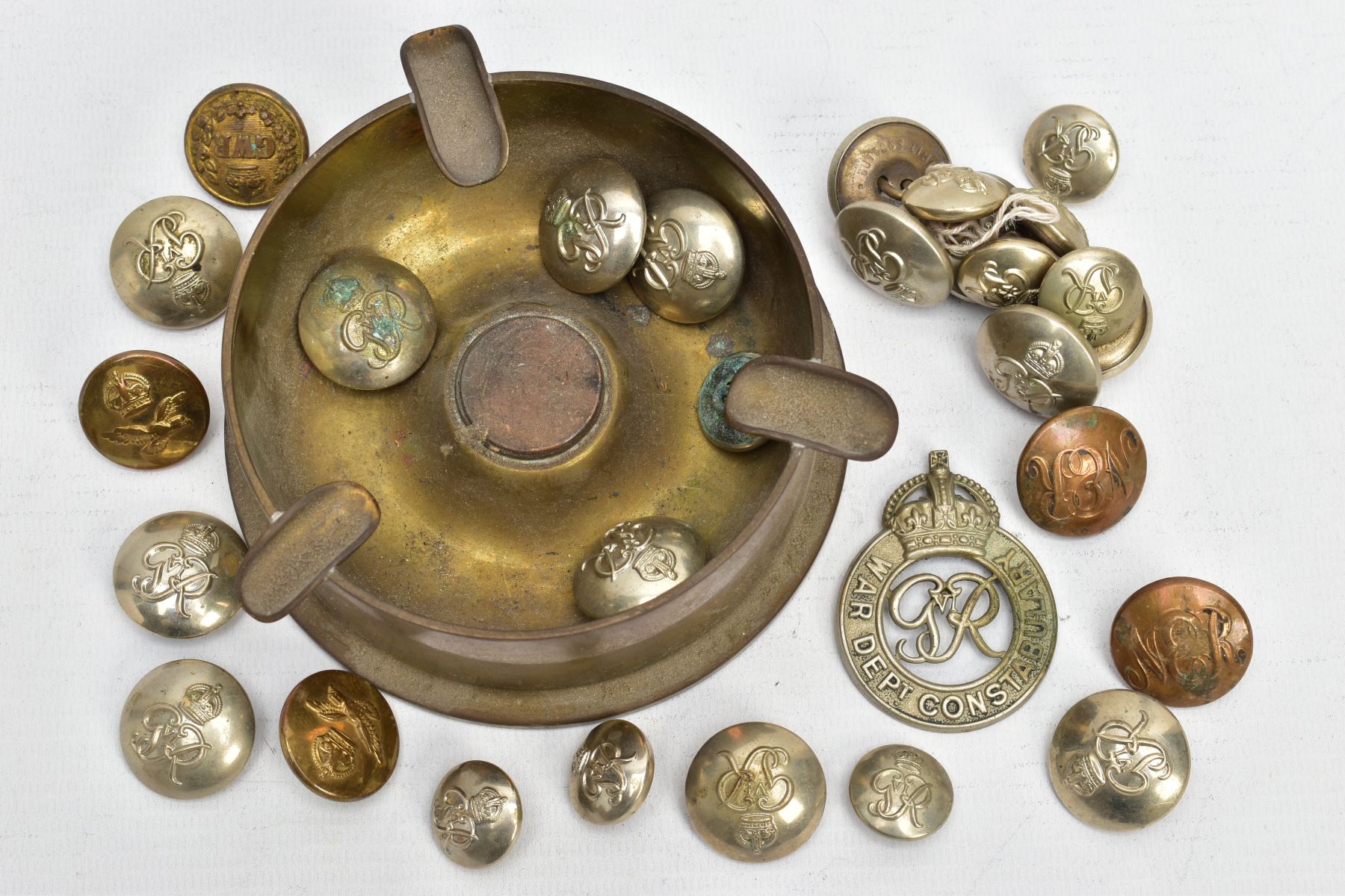 A WORLD WAR TWO DATED SHELL, 1938 fashioned into an ashtray with a number of Military buttons WWI/II