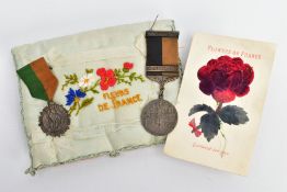 A SMALL WORLD WAR ONE ERA cushion with ornate stitching and a frieze of Fleurs de France, well-